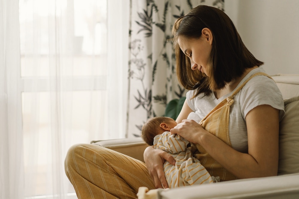 mother in chair in nursery breastfeeding baby