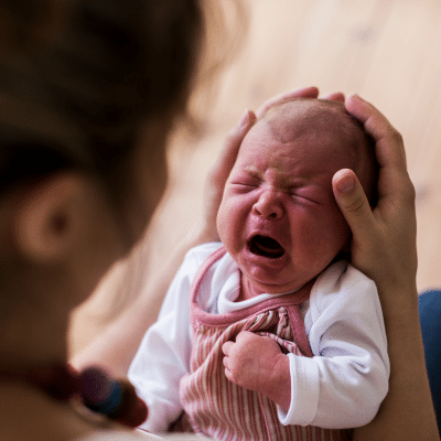 Understanding colic 3 Crying baby held by caregiver, representing signs of colic